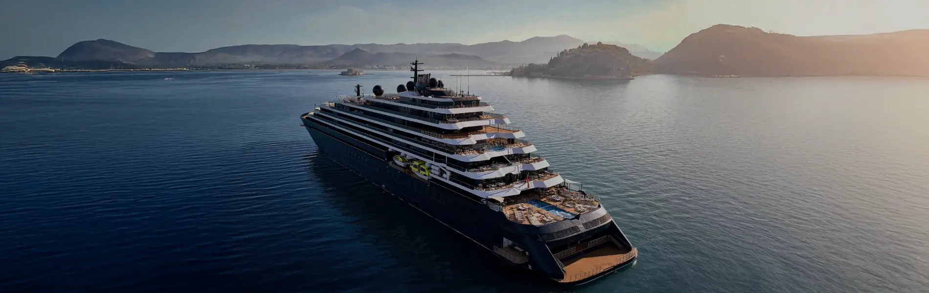 Yate de lujo de The Ritz-Carlton navegando al atardecer con servicio a bordo exclusivo